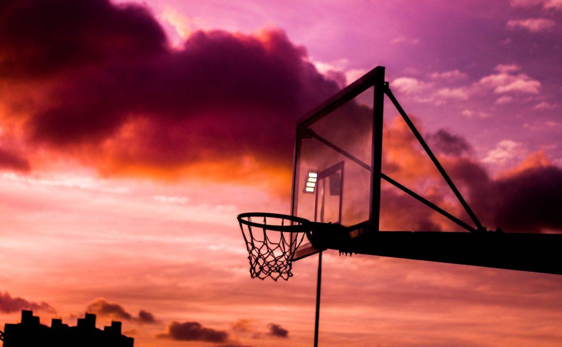 silhouette photo of basketball hoop during golden hour